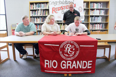 Lawrence County High's Brandon Stevens signs with Rio Grande as his parents and Rio head coach Brad Warnimont look on